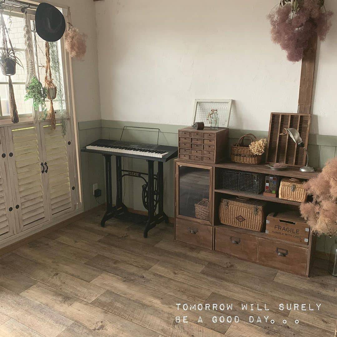 古材調のクッションフロアをリビングに敷いた実例。ダークトーンの家具と合わせて落ち着きのある雰囲気に仕上がっている。