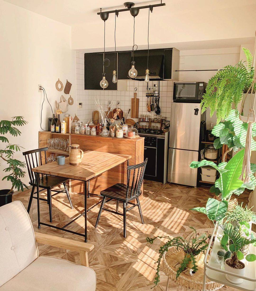 パーケット柄のクッションフロアをキッチンとダイニングに敷いた実例。観葉植物や木製家具と調和し、温かみと洗練さを両立した空間。