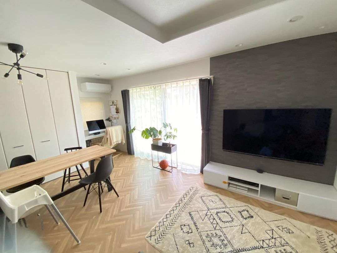 ヘリンボーン柄のクッションフロアをリビングに敷いた実例。観葉植物や木製家具と組み合わせて温かみのある雰囲気に仕上がっている。