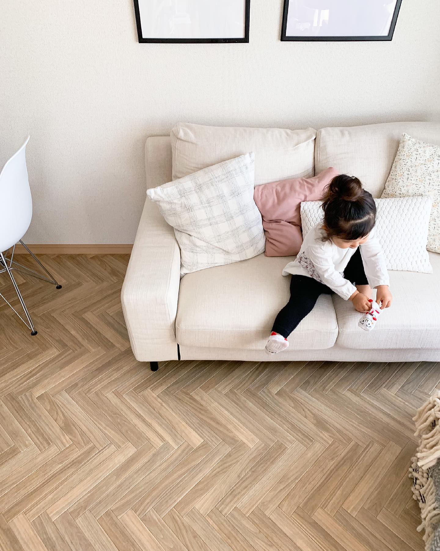 ヘリンボーン柄のクッションフロアをリビングに敷いた実例。ベージュ系ソファやインテリアと調和し、明るくやわらかな雰囲気に仕上がっている。