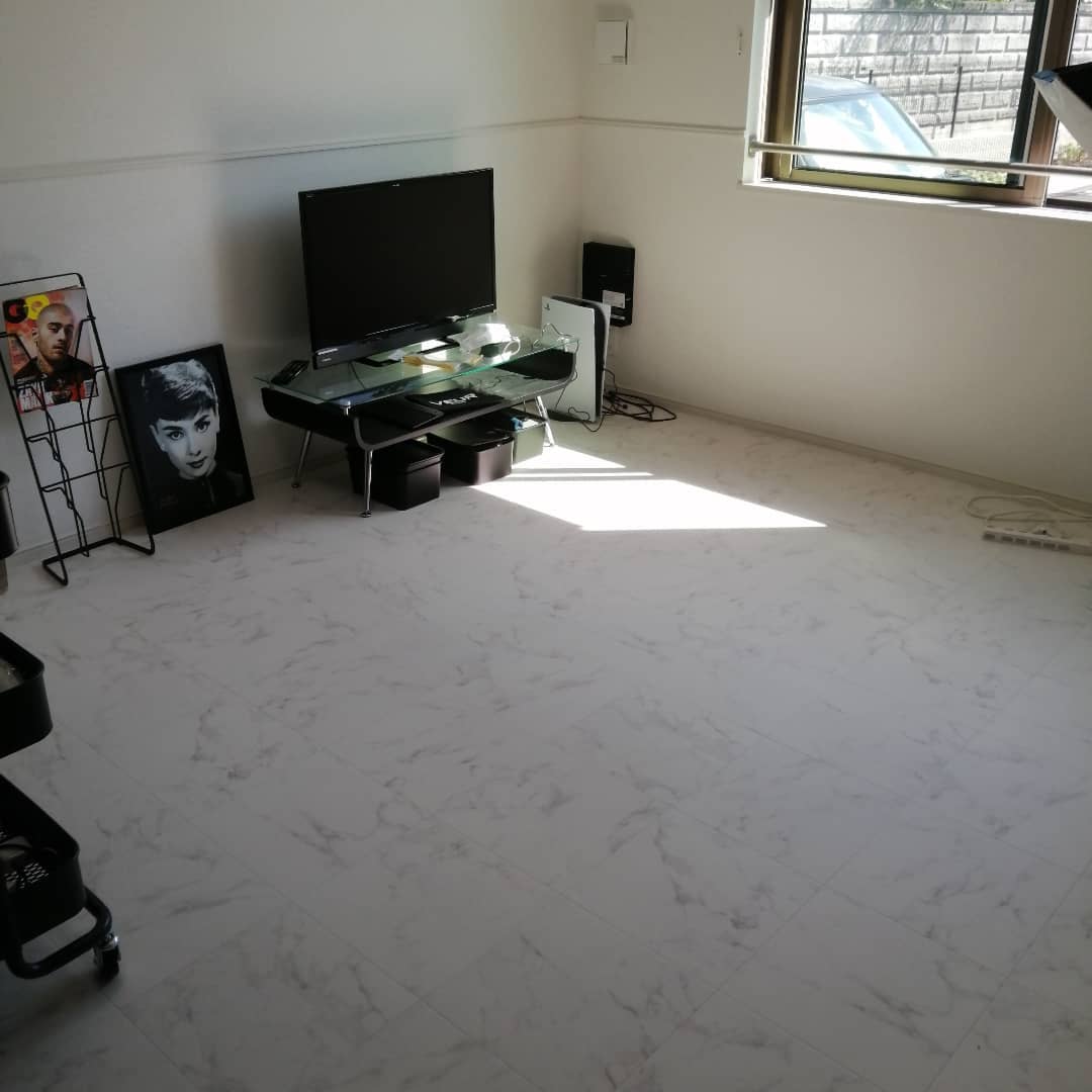 白い大理石柄のクッションフロアをリビングに敷いた実例。モノトーンの家具と相性がよく、スタイリッシュで洗練された空間になっている。