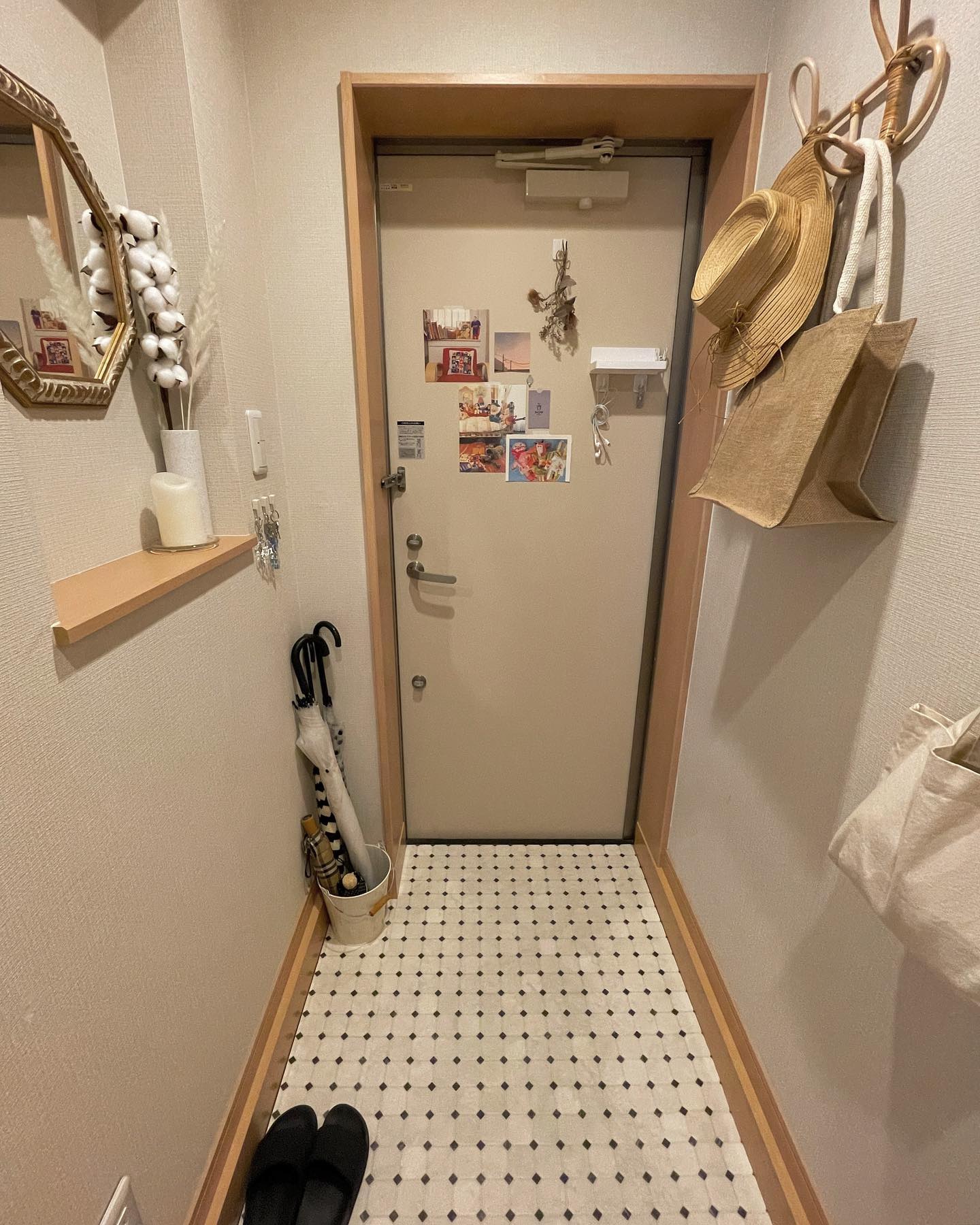 賃貸の玄関に敷かれた白地に黒ドット柄のタイル調クッションフロア。狭い玄関でも明るくおしゃれに見える実例。