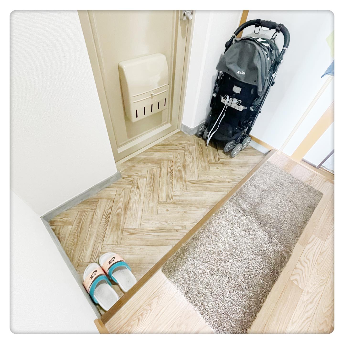 玄関にヘリンボーン柄のクッションフロアを敷いた実例。ナチュラルな木目調で空間を上品に仕上げている。”