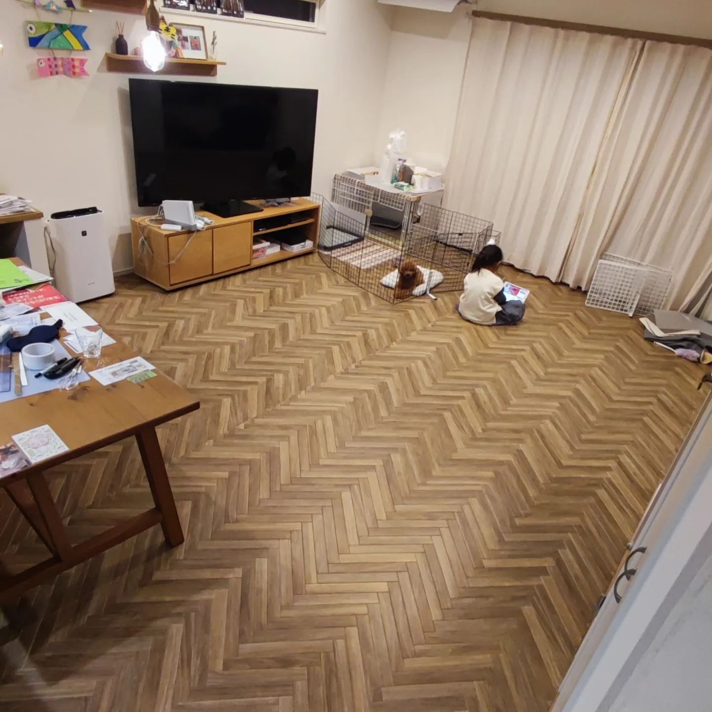 ヘリンボーン柄のクッションフロアをリビングに敷いた実例。子どもとペットが一緒に過ごす空間で、あたたかみのある雰囲気に仕上がっている。