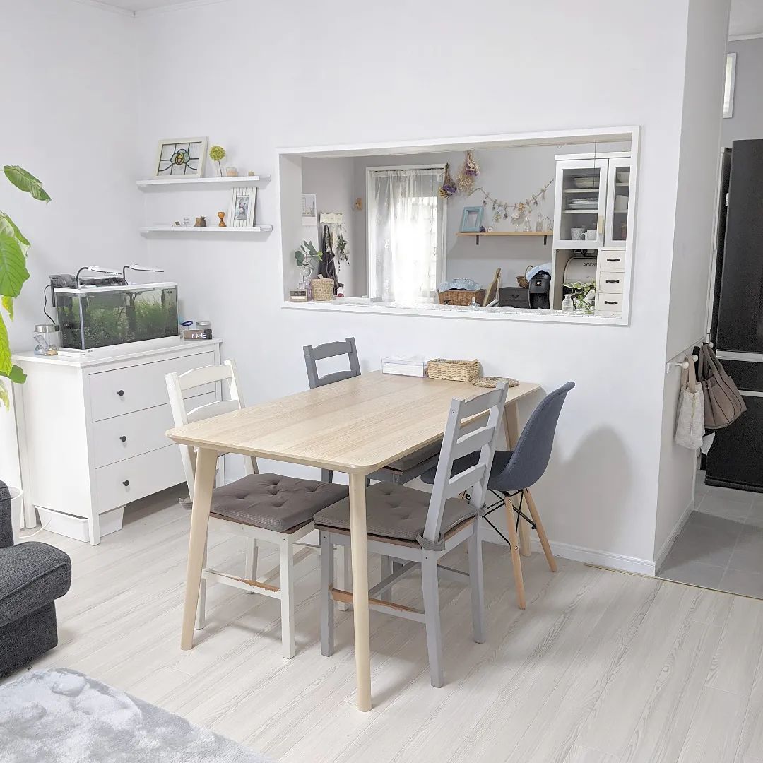 ホワイトウッド調のクッションフロアを敷いたリビングダイニング。ナチュラルな木製テーブルやグレーのチェアと組み合わせて、シンプルで明るい北欧風インテリアに仕上がっている。