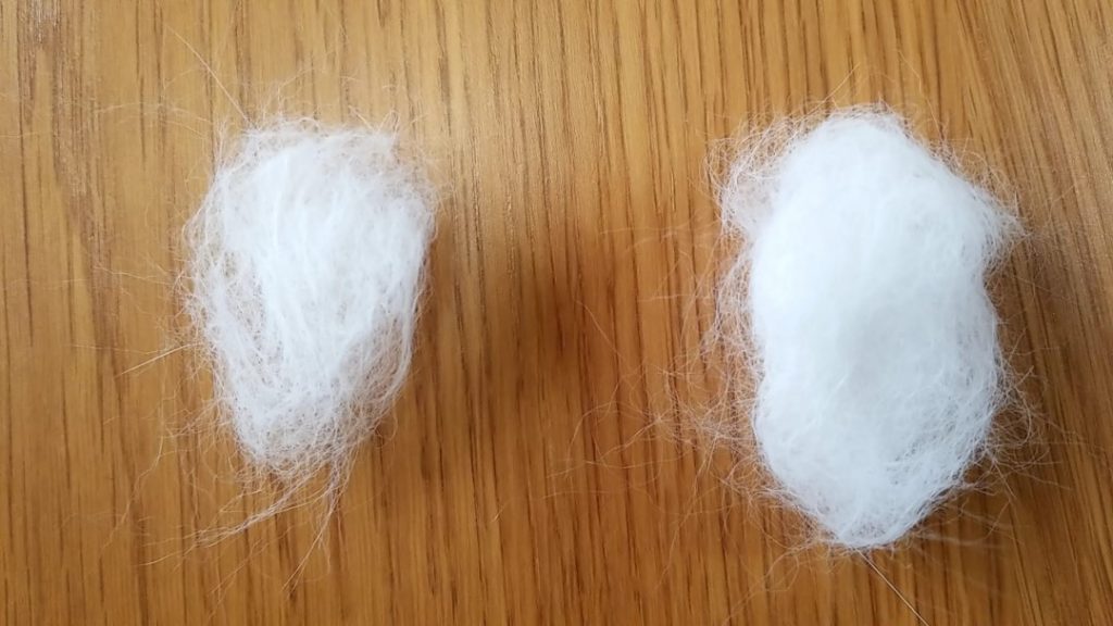 木目調の床に落ちたペットの抜け毛。日常的な床汚れの原因となるペットの毛の散乱を示す。