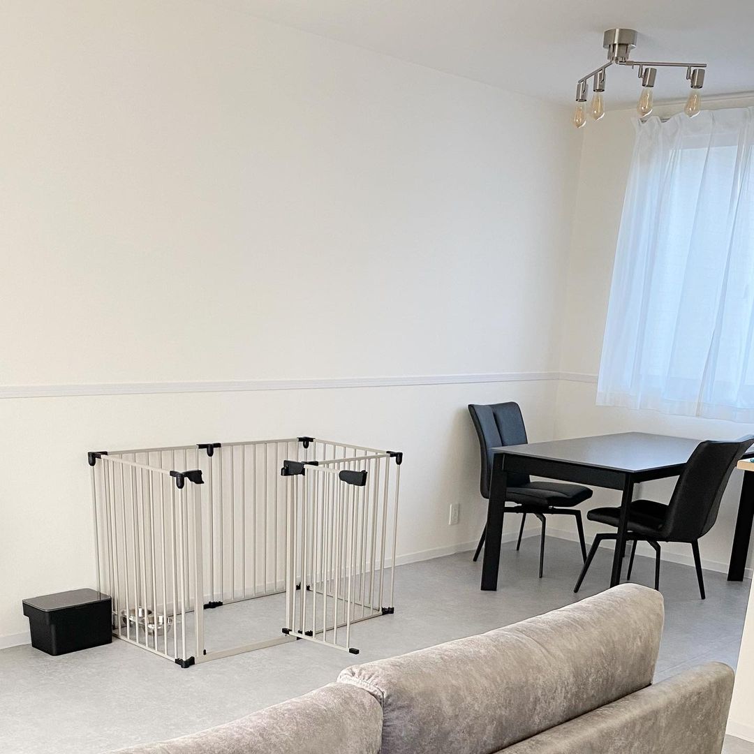 グレー系のクッションフロアを敷いたリビングダイニング。ブラックの家具とホワイトの壁が調和し、モノトーンでスタイリッシュな空間に仕上がっている。