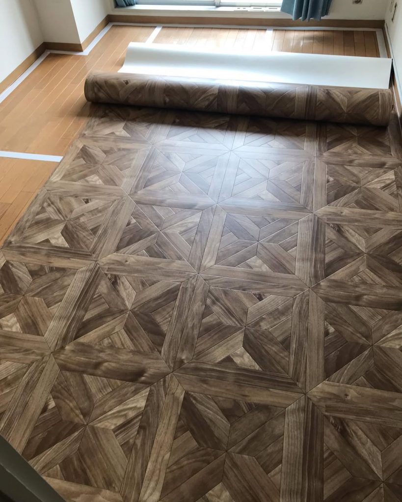 新居の床 DIY クッションフロア施工途中。パーケット柄のクッションフロアを広げるようす