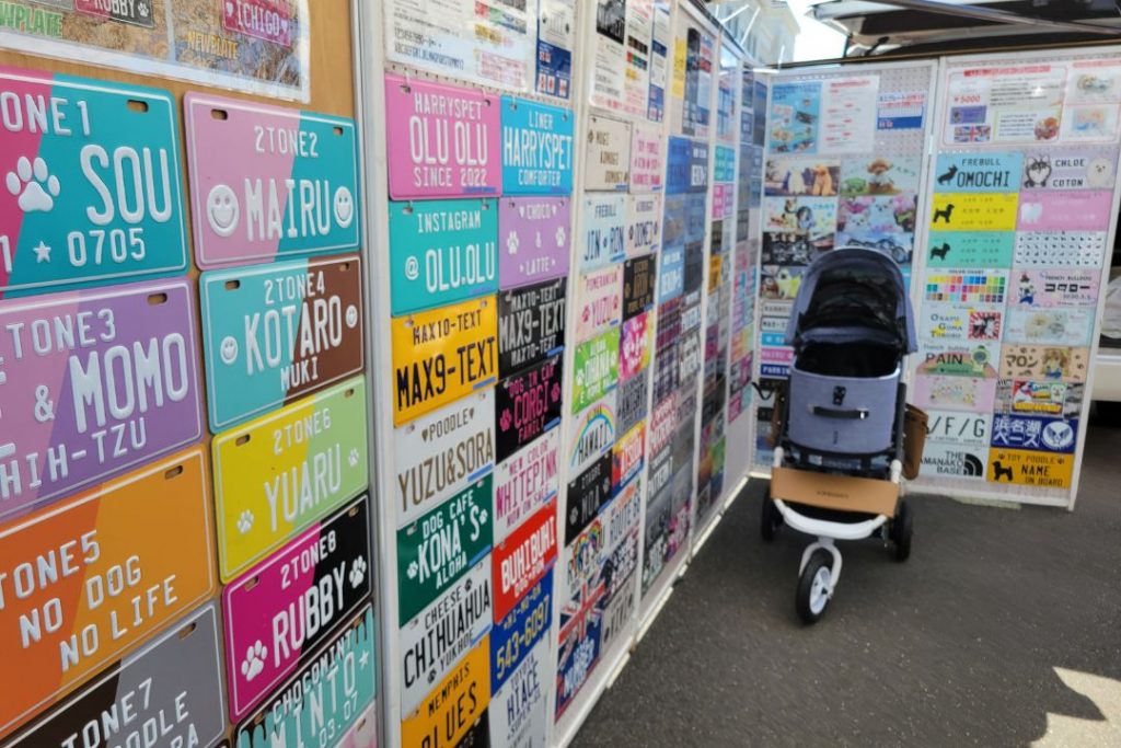 WANDARAKE MARCHÉのオリジナル犬用ナンバープレート販売ブース:様々な色やデザインのプレートに、犬の名前やメッセージ、シルエットなどがプリントされている。愛犬だけの特別なグッズを作ることができる。