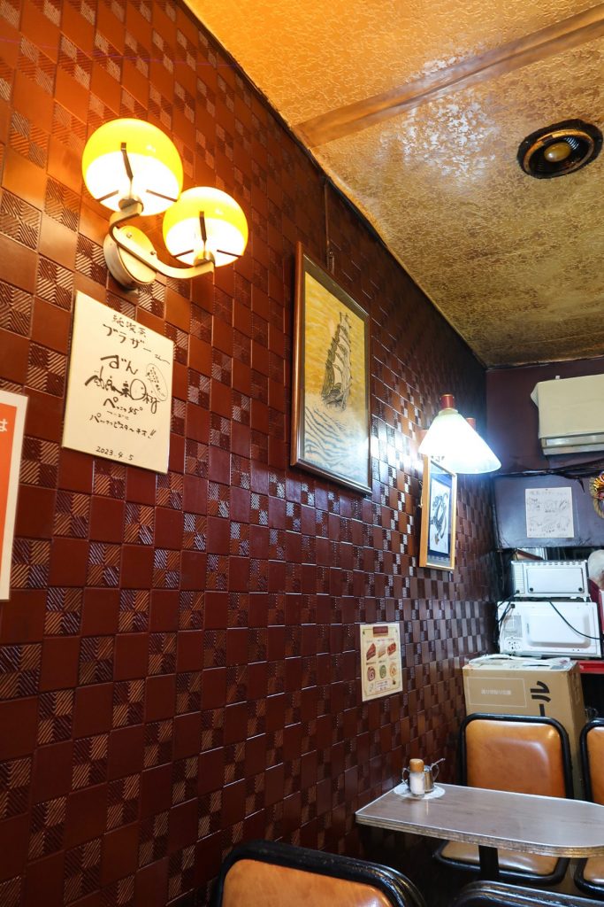 赤茶色の市松模様の壁とあたたかみのある照明|純喫茶ブラザーの店内ディテール
