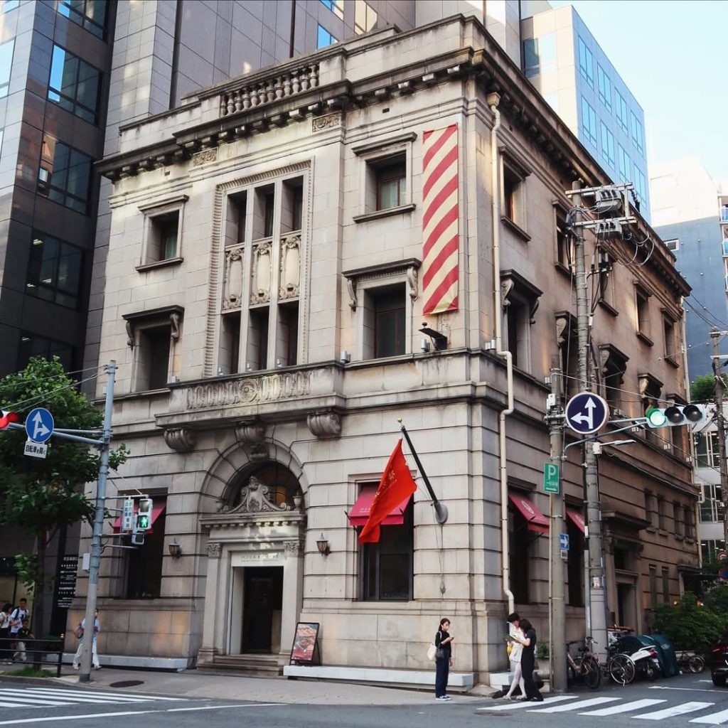 昭和6年築の川崎貯蓄銀行大阪支店の建物を活用した『パンとエスプレッソと堺筋倶楽部』の外観|クラシカルな石造りの建築と赤い日よけが印象的