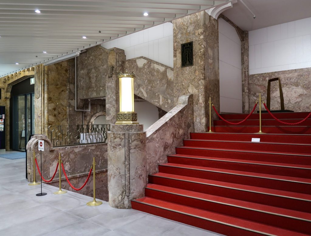 大理石の壁と赤い絨毯階段が印象的な高島屋東別館1階ロビー|重厚な装飾が美しい昭和初期建築の内装