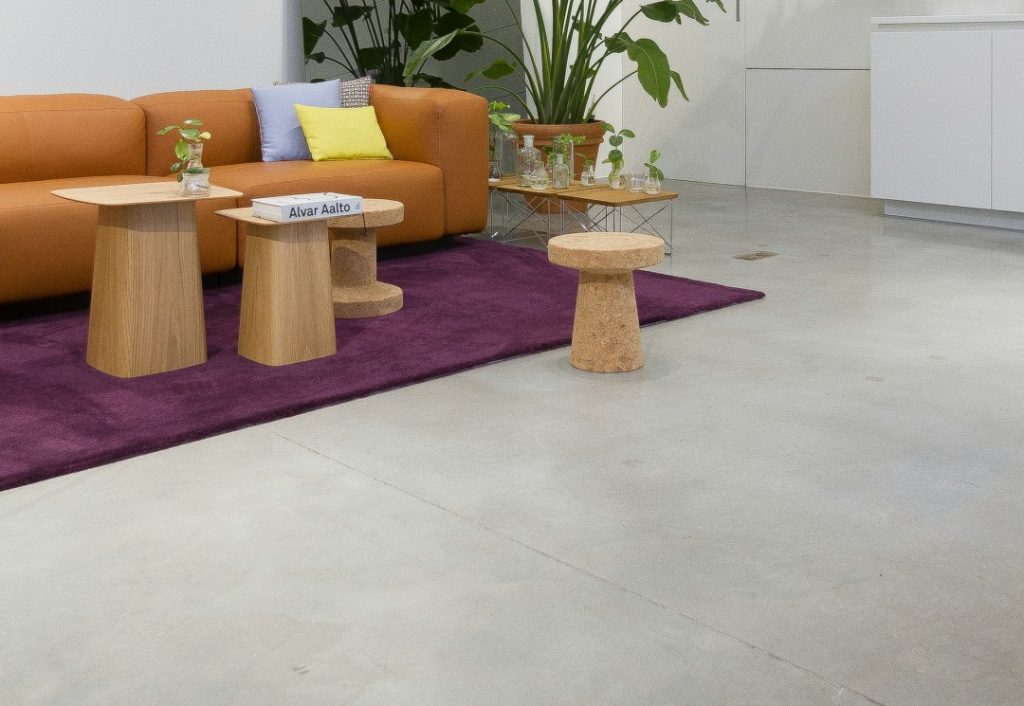 モルタル風の床に映える北欧スタイルのリビング。パープルのラグとオレンジのソファがアクセントになった洗練空間