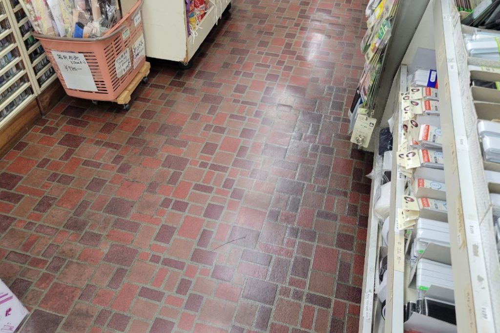 岡崎の商店街にある布地・洋裁用品店の店内床。赤系タイル柄の床がレトロな雰囲気を醸し出している