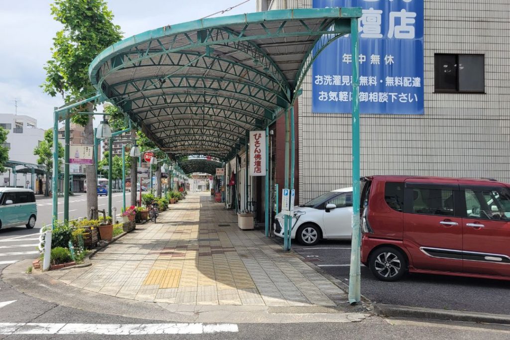 岡崎の連尺通り商店街のアーケードと歩道の床風景。グリーンの屋根とレンガ調の床がレトロな雰囲気を演出している