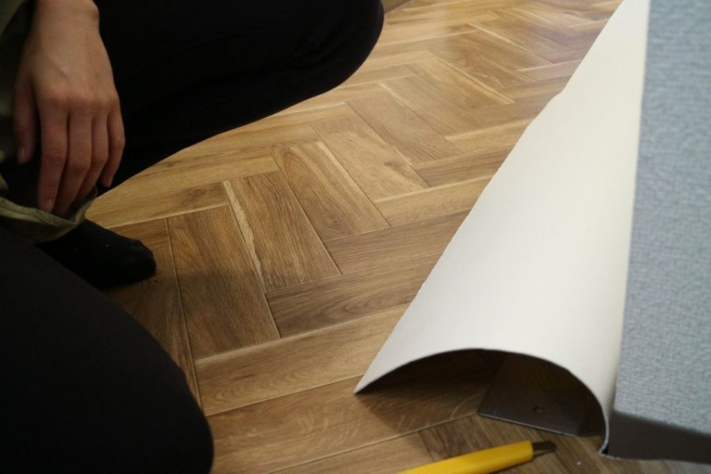 クッションフロアを床に敷く施工イメージ写真。木目調デザインのクッションフロアは住宅や店舗の床DIYに幅広く使える