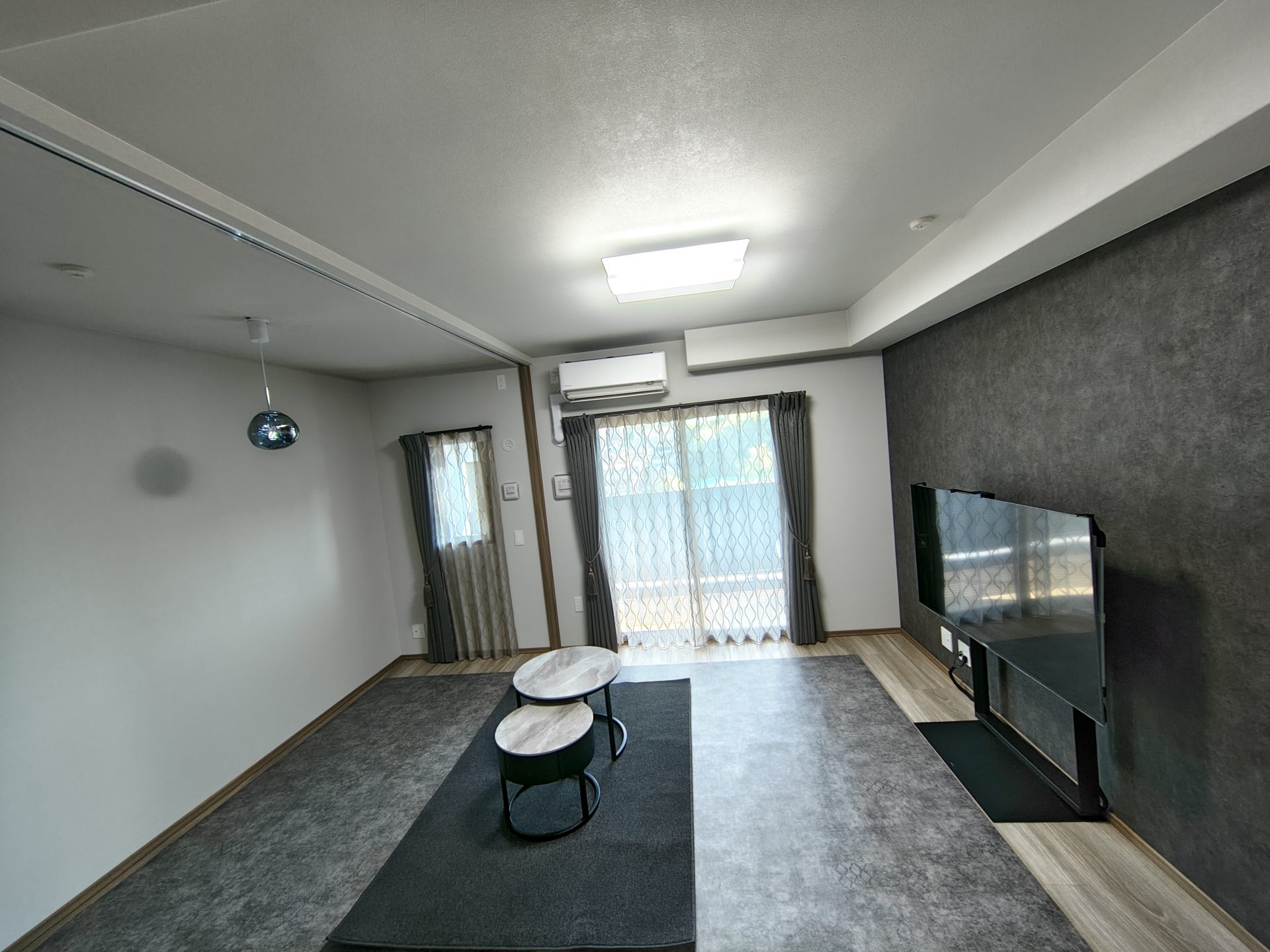 ラグリエのアンティーク調フロアマット〈グレーボヘミア〉184cm幅(継ぎ目なし)をリビングにラグのように敷いた室内。上品なグレーの模様がアクセントとなり、空間をおしゃれに演出している様子。