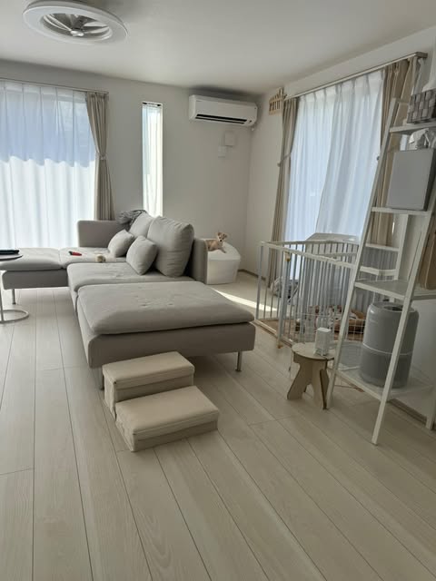 まだマットを敷く前の明るいリビング全景。白を基調にした家具と開放的な窓が印象的。