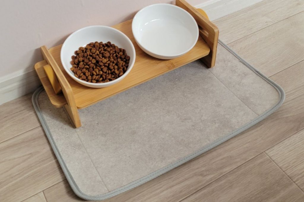 ラグリエのペット用食事マット「mogmog」ベントタイル柄を使用。木製のフードスタンドにフードボウルと水入れを置いた、ナチュラルな床DIYスタイルの食事スペース。