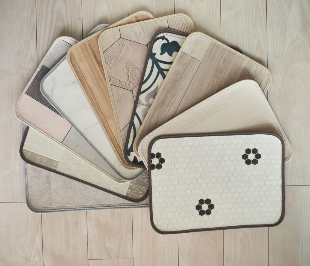 ラグリエのペット用食事マット「mogmog」全10柄を並べた様子。木目・タイル・大理石・モロッカンなど多彩なデザインを重ねて配置。