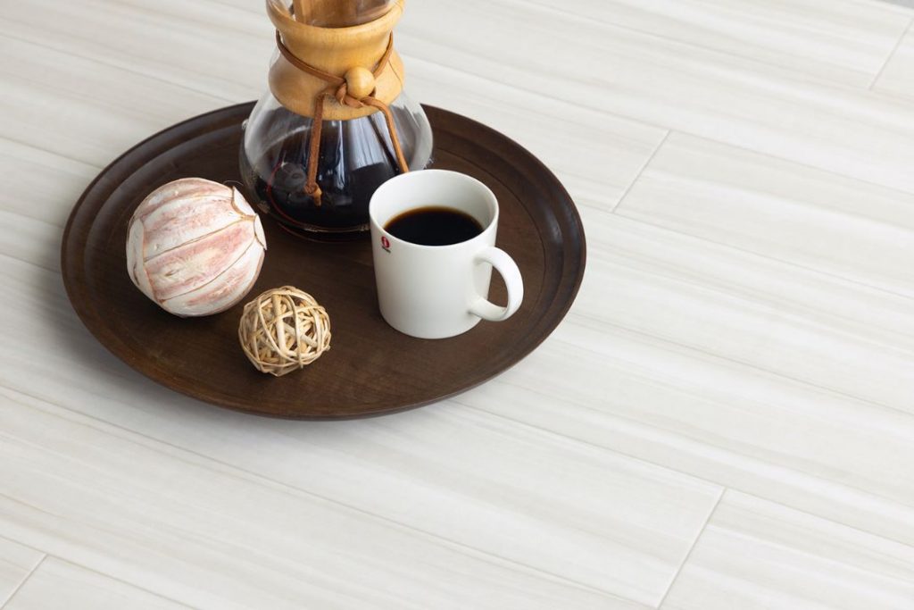 ラグリエのアーバン フロアマット ティネオ 92cm幅。ホワイトグレーの木目柄がナチュラルモダンな雰囲気を演出し、カフェ風インテリアや雑貨とも調和する。