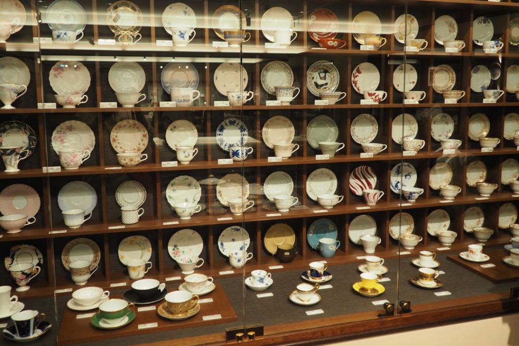 ノリタケミュージアムで展示されている多様なデザインのカップ＆ソーサーのコレクション棚。