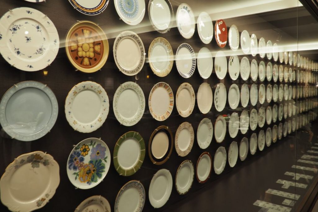 ノリタケミュージアムで壁一面に展示された多彩なデザインの洋皿コレクション。