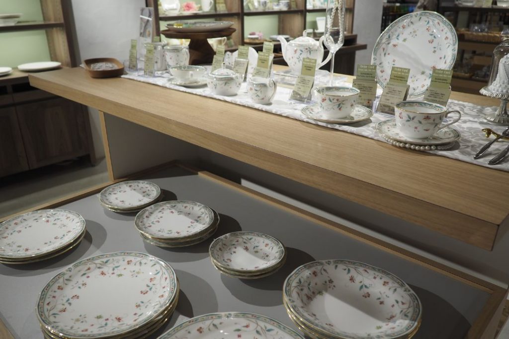 ノリタケの森ショップで並ぶ花柄のテーブルウェアを撮影した展示棚。