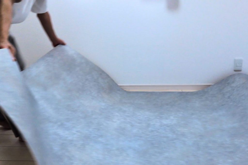 ラグリエのペットマット〈モルタル〉を賃貸リビングに広げている作業途中の写真。