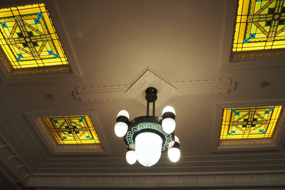 名古屋市市政資料館の天井装飾。黄色を基調としたステンドグラスとクラシックな照明。