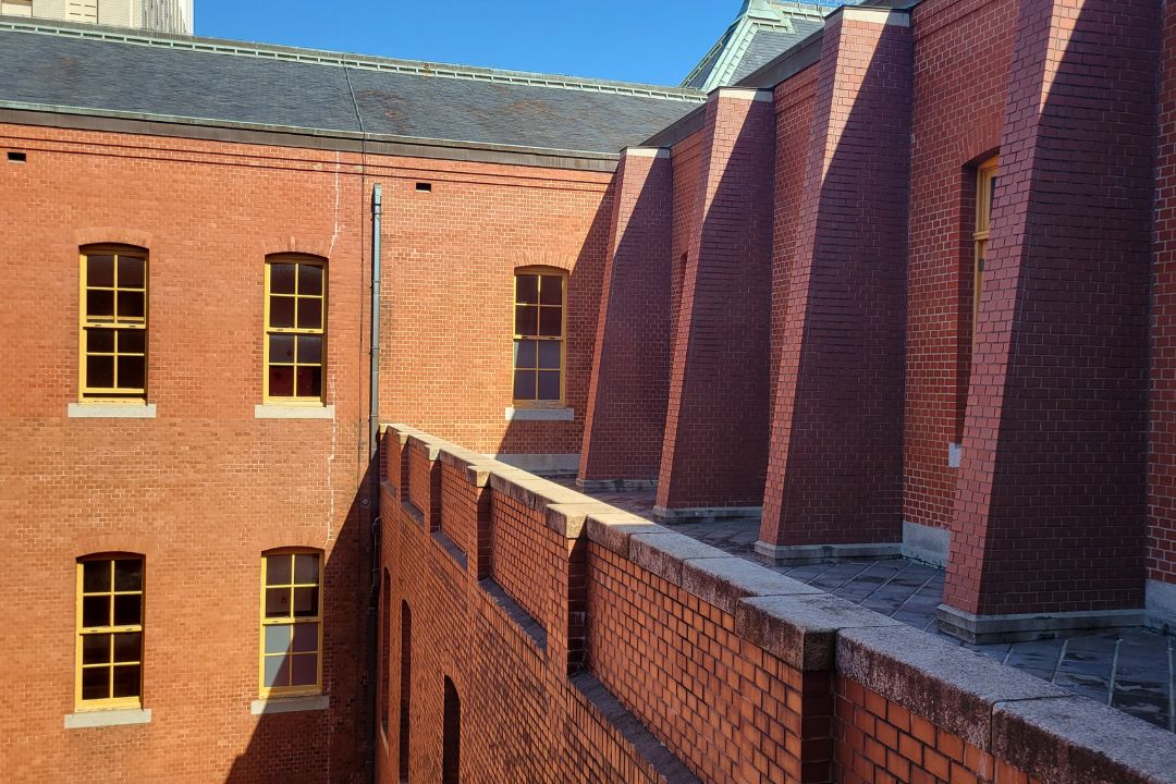 名古屋市市政資料館の外壁。赤レンガの壁と凹凸構造が陽光で陰影をつくる中庭側の外観。