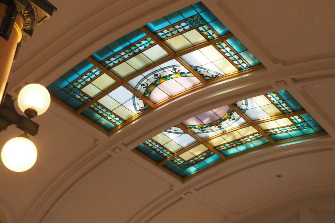 名古屋市市政資料館の天井に施されたステンドグラス。青や緑を基調にした幾何学的な美しいデザイン。