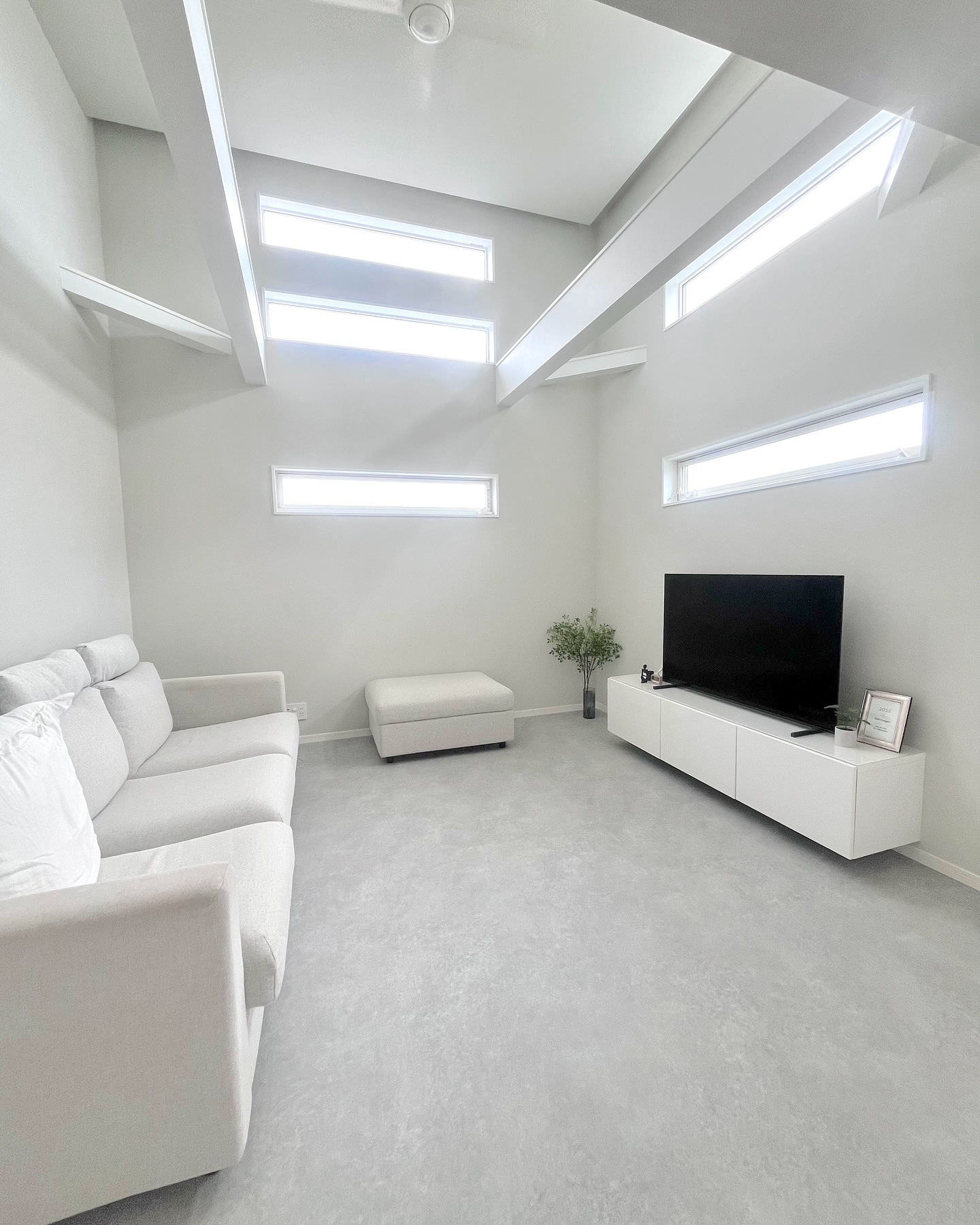 モルタル柄クッションフロアを敷いたリビング。落ち着いたグレーと家具が調和したインテリア