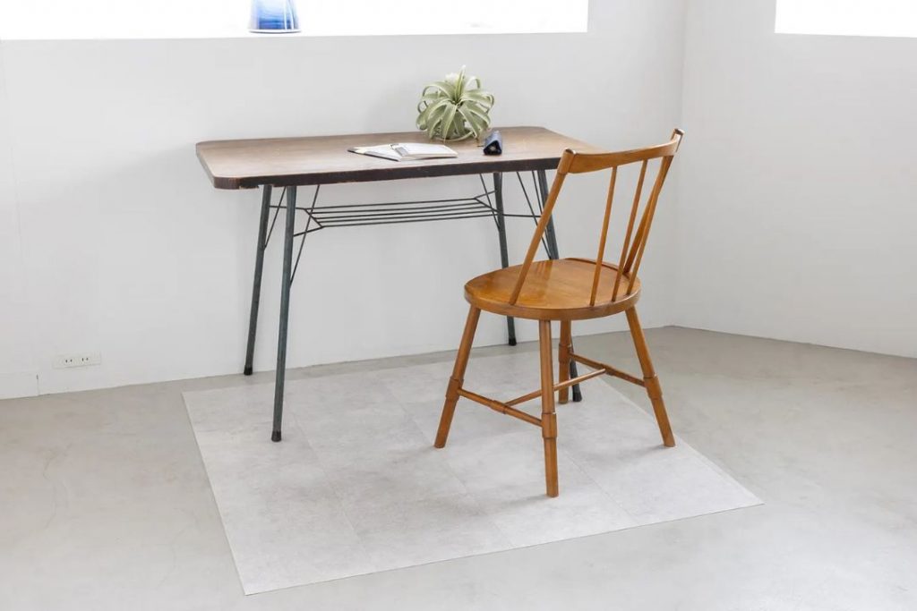 ラグリエのタイル柄 チェアマット マットグレージュをデスク下に敷いた使用イメージ。木製チェアとアイアン脚デスクを合わせた、落ち着いたワークスペース。
