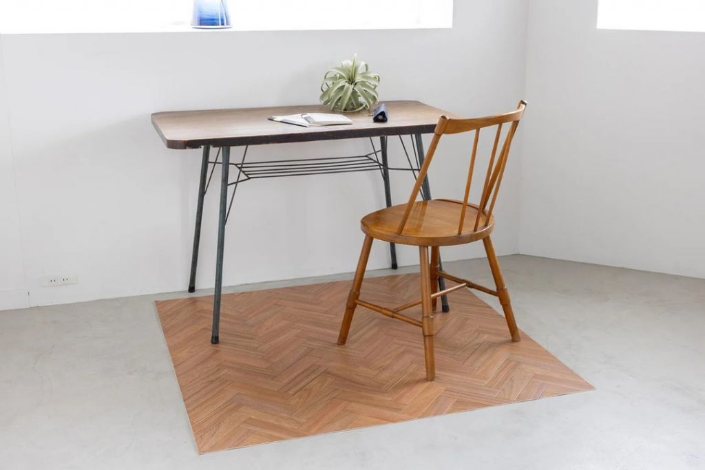 ラグリエのヘリンボーン チェアマット マホガニーをデスク下に敷いた使用イメージ。木製チェアとアイアン脚デスクを合わせたカフェスタイルのワークスペース。