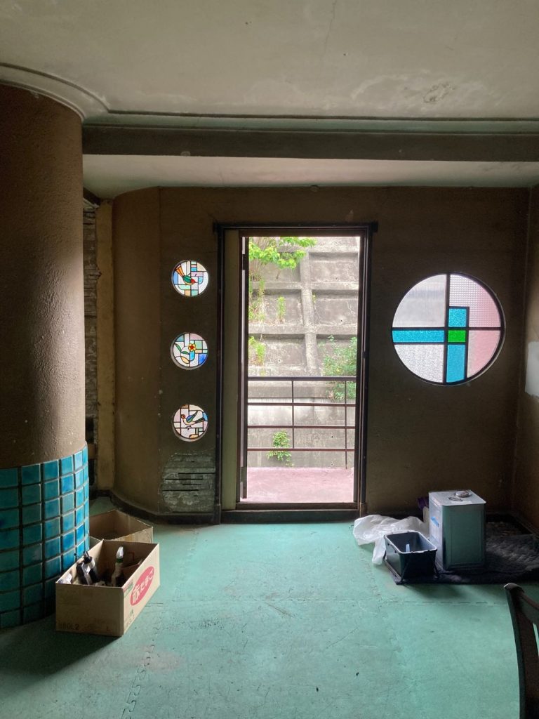 旧加島楼2階、丸窓と円形ステンドグラスが並ぶ一角。外へ通じる扉があり、アールデコ調の意匠が特徴的。