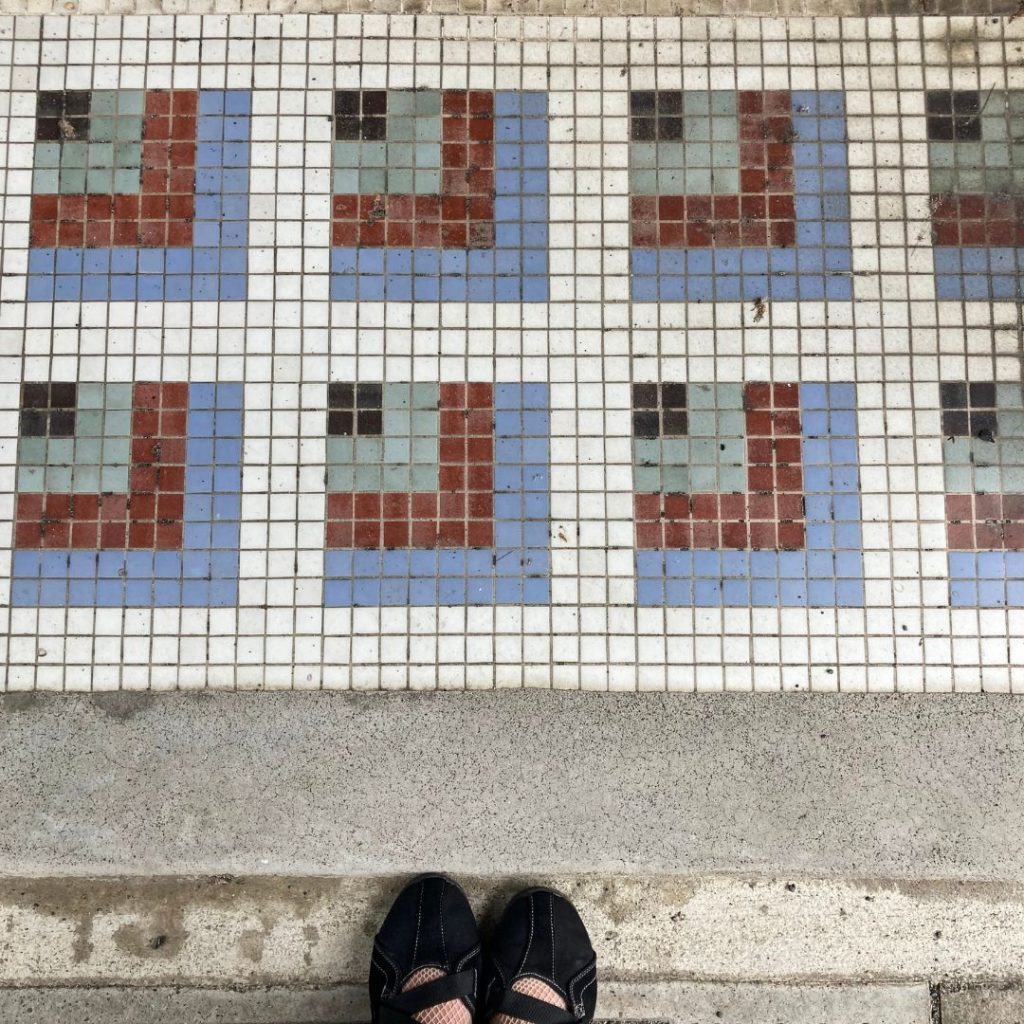 京都の軒先で見つけた四角タイルの床。水色・赤茶・薄緑を組み合わせた幾何学模様がおしゃれに並ぶデザイン。