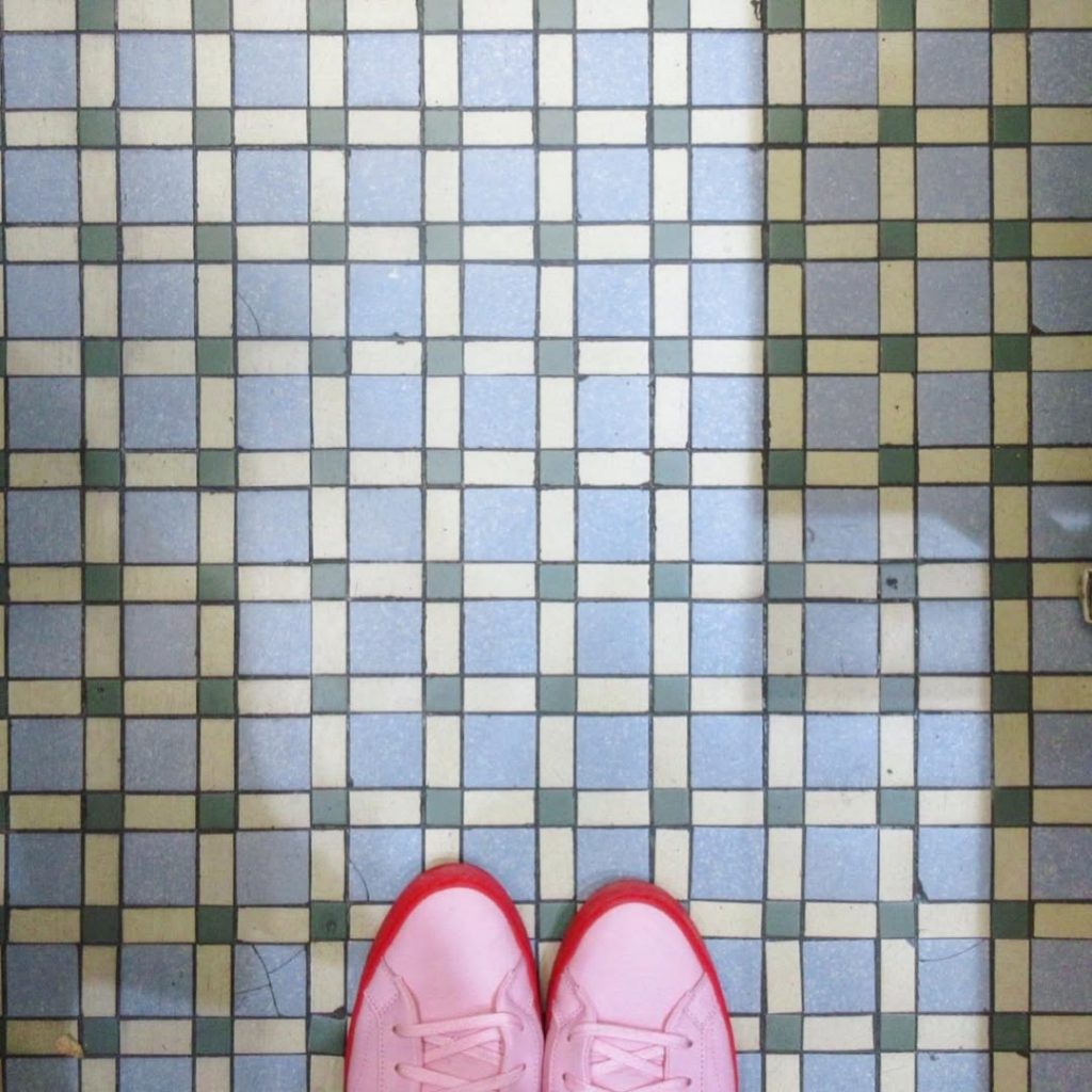 奈良の商店街にある、淡いブルーとアイボリー、グリーンの小さな正方形タイルが格子状に並ぶ床。