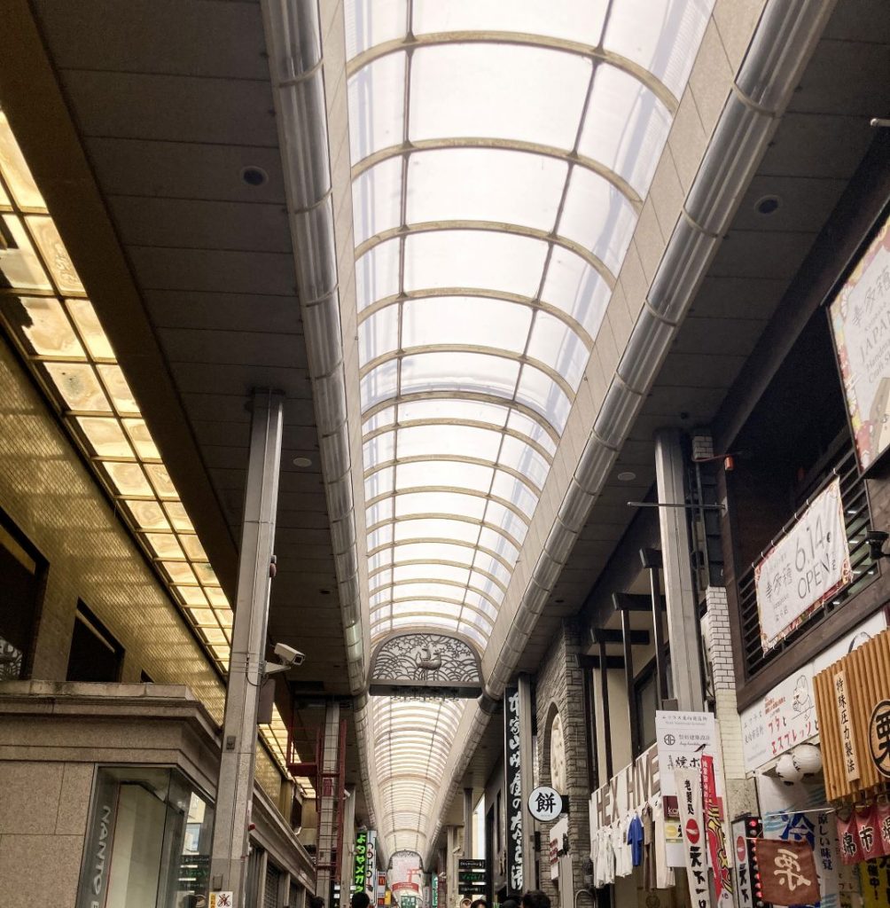 奈良駅へと続く商店街の通り。アーケード天井が続き、飲食店や土産物店の看板が並ぶにぎやかな風景。