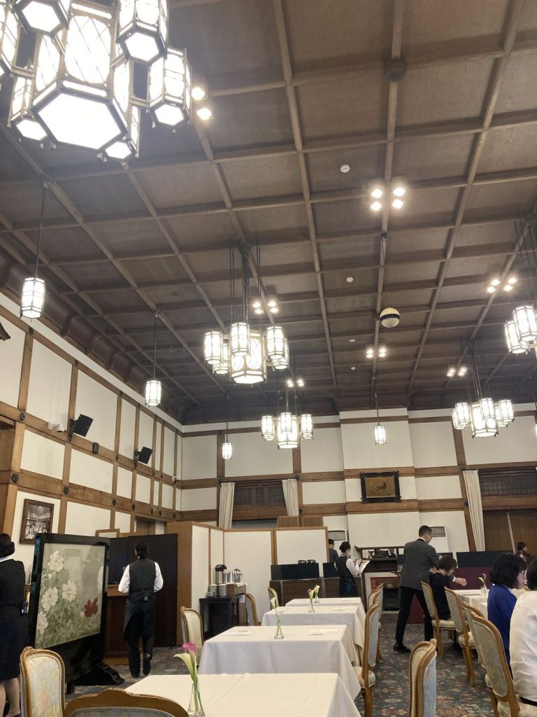 今井晶子の床旅で訪れた奈良ホテルのダイニングルーム。高い格間天井と吊り下げ照明が空間全体に品格と開放感をもたらしている様子。