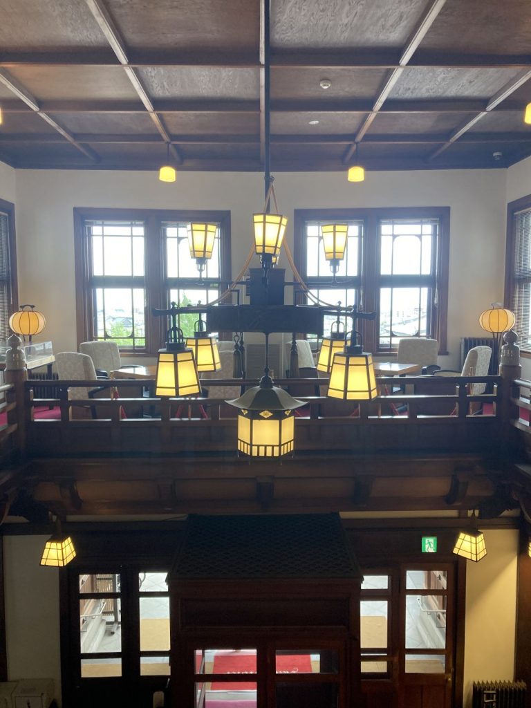 奈良ホテルのロビー。吹き抜け上部に設えられたシャンデリアと、木組みの天井が印象的な空間。