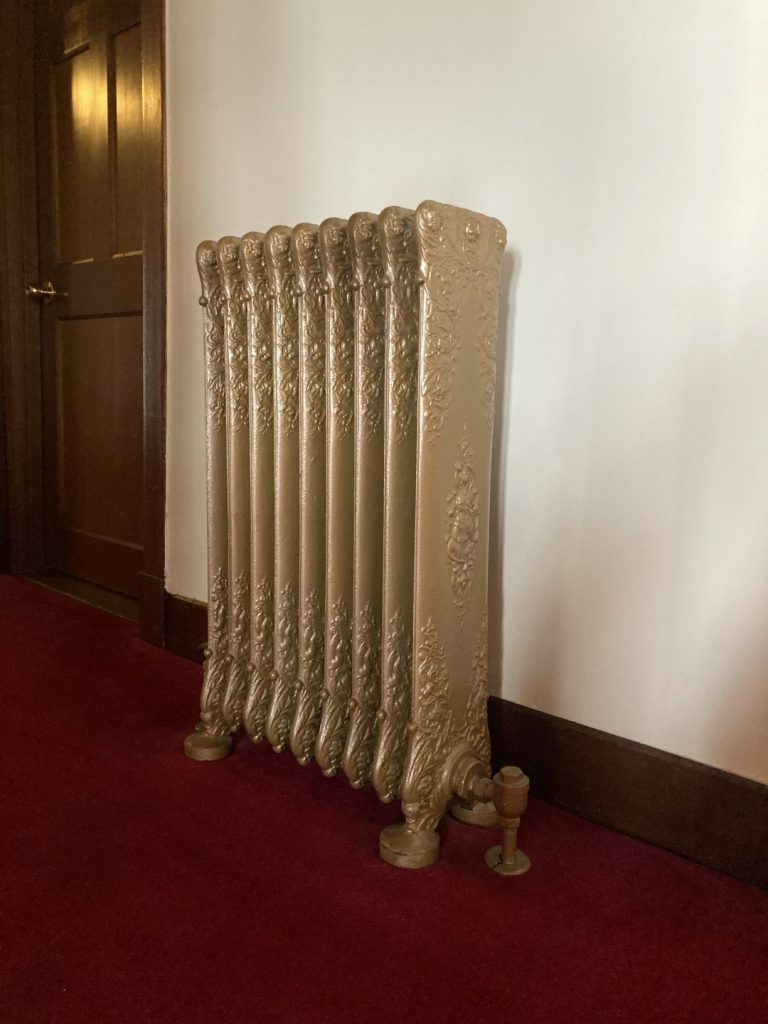 奈良ホテル本館の廊下。現在は使用されていないものの、大正3年に設置された装飾的なスチームヒーター。