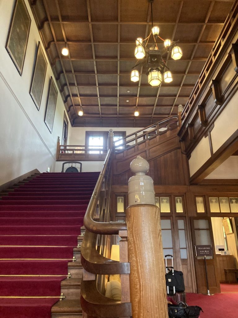 奈良ホテルの館内。赤いカーペットが敷かれた階段と、手すりに配された擬宝珠付きの高欄が印象的な空間。