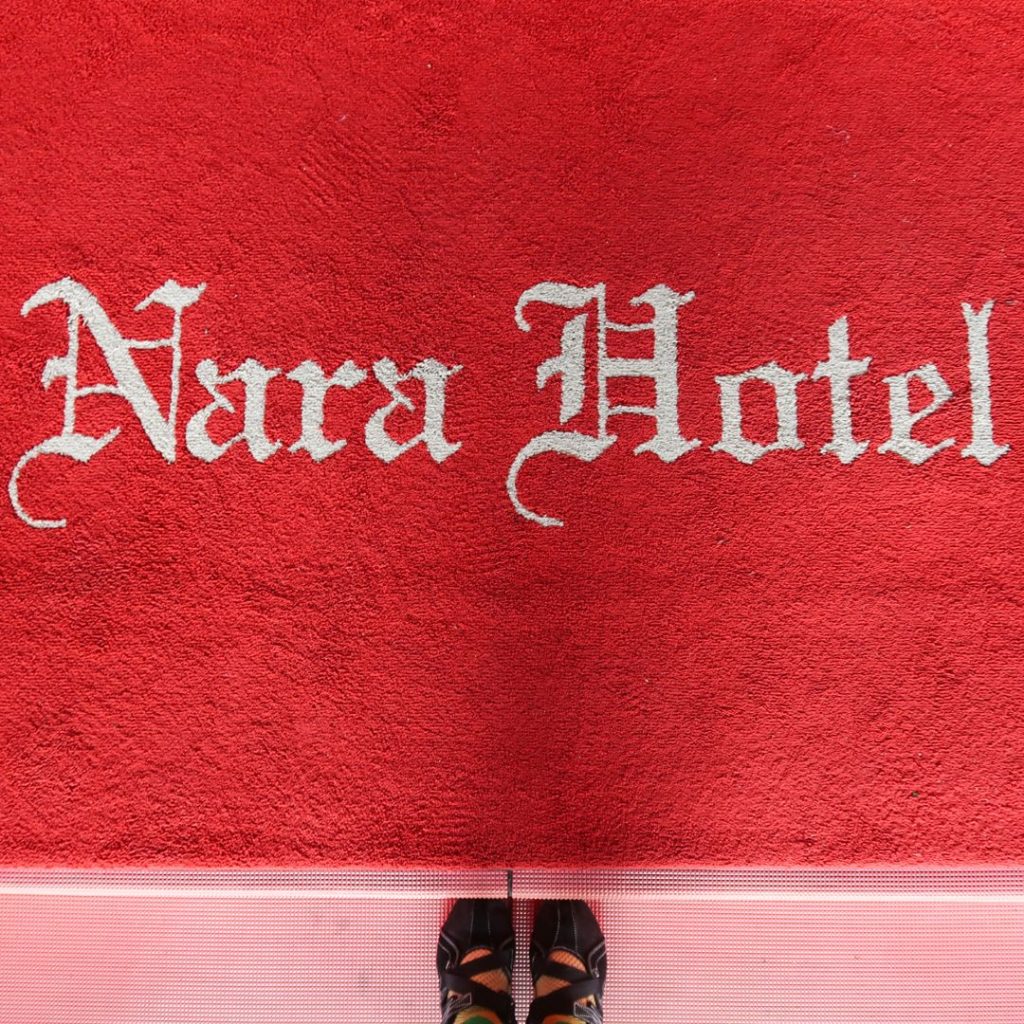 奈良ホテルのエントランス。赤いカーペットに「Nara Hotel」の文字があしらわれた、印象的な床マット。