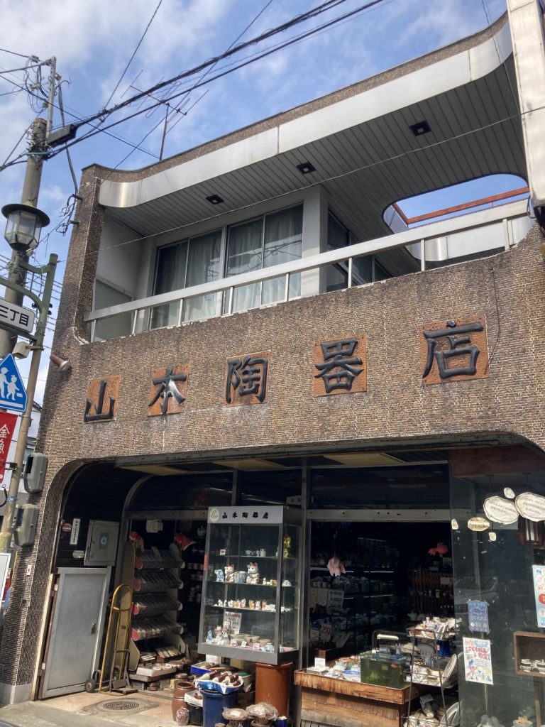 大和郡山商店街にある「山本陶器店」の外観。レトロな建物正面に店名の看板が掲げられ、店先に陶器や雑貨が並んでいる。