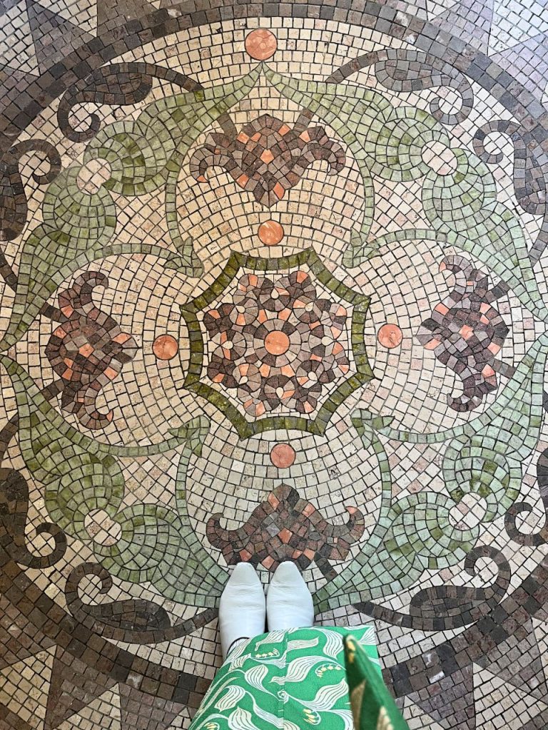 東京都庭園美術館の玄関モザイクタイル中央部。花を思わせる円形文様と蔦模様が組み合わされた装飾床。