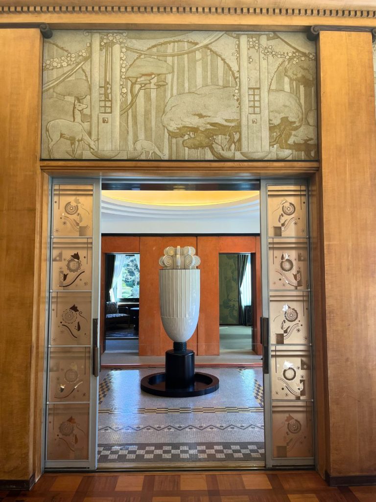 東京都庭園美術館の香水塔とホール空間。中央に立つ白い香水塔と幾何学模様の床タイル。