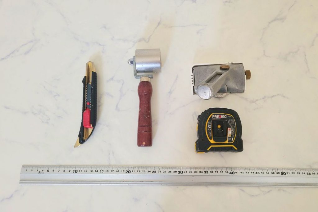 ラグリエのデザインフロアマット施工で実際に使用した職人の道具一式。カッター・ローラー・溝切り工具・メジャー・定規など床施工に必要な専門工具。