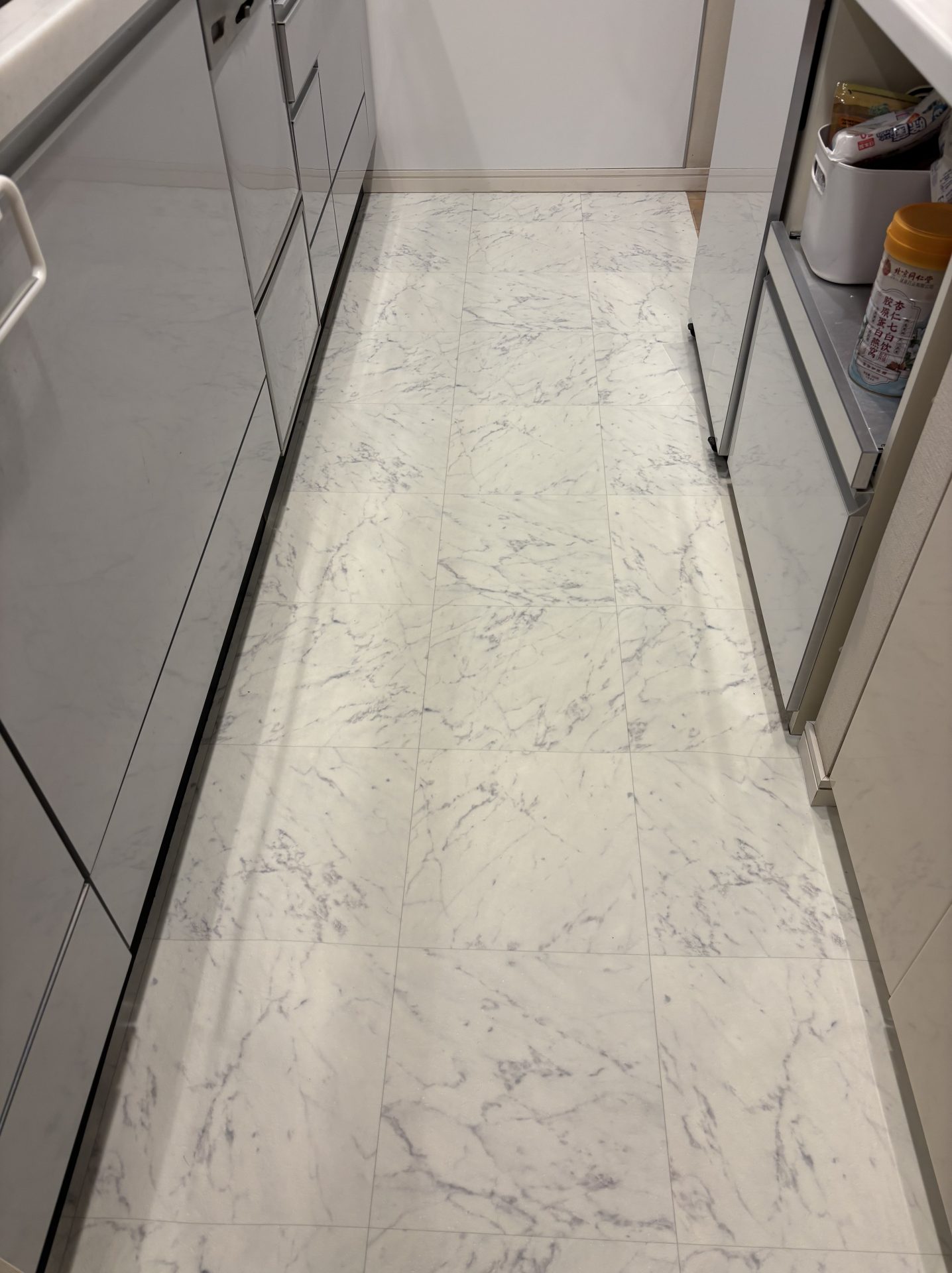 ラグリエのペットマット 大理石柄をキッチンの床に敷いた様子。白い大理石調の床が明るく、フローリングよりすべりにくく掃除もしやすいキッチン床DIY。