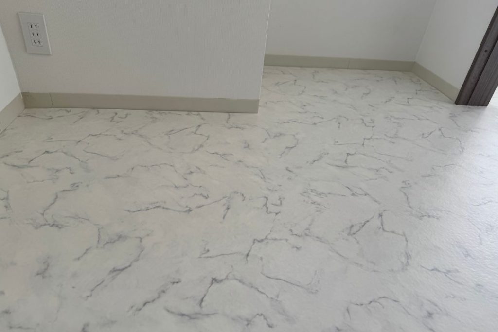 ラグリエのデザインフロアマット〈大理石柄・184cm幅〉を賃貸住宅に施工したリビングダイニングの完成写真。壁際まで丁寧に納められた明るい床DIYの仕上がり。